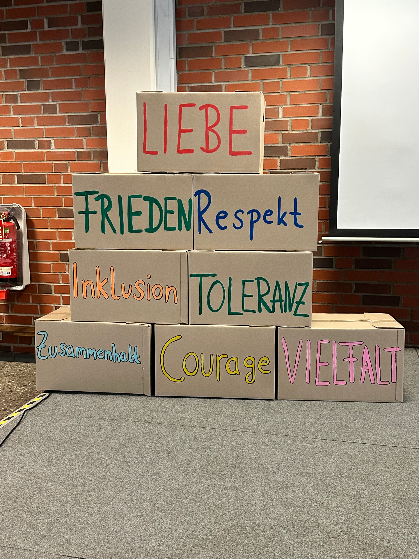 Kartons mit den Werten Liebe, Frieden, Respekt, Inklusion, Toleranz, Zusammenhalt, Courage und Vielfalt