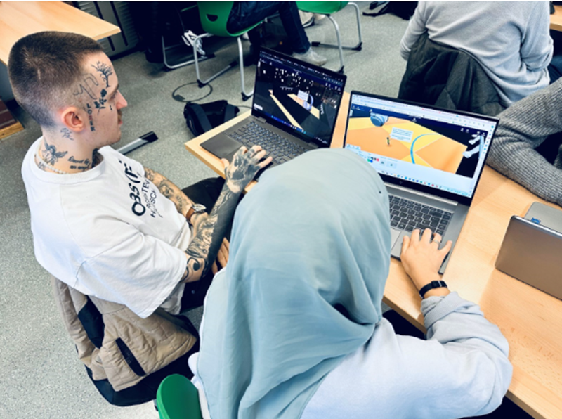 Lernende arbeiten gemeinsam an Laptops und entwickeln virtuelle 3D-Welten